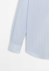 Light blue long-sleeve shirt featuring a smooth texture, pointed collar, and a buttoned cuff with a rounded hem.