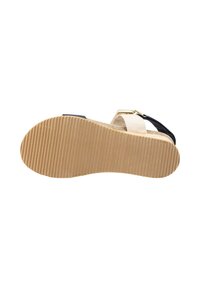 Sandal negra y beige con una suela marrón texturizada y estriada, que presenta una cinta superior trenzada y un cierre metálico.