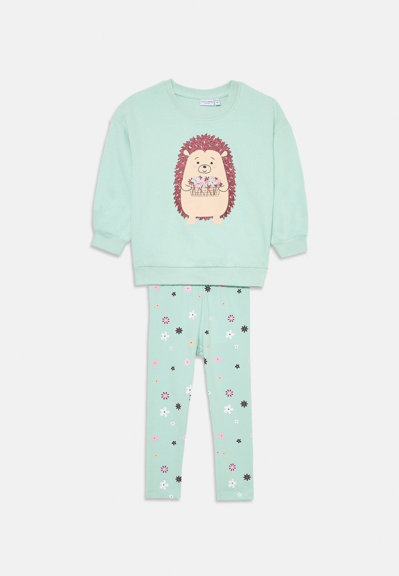 Conjunto de algodão verde menta com uma blusa de mangas longas com um gráfico de ouriço e leggings correspondentes decoradas com padrões florais coloridos.