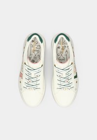 Sneaker in pelle bianca con dettagli verdi, decorazioni floreali pastello e scritte colorate "LOVE" sui lacci. Solette grafiche notevoli.