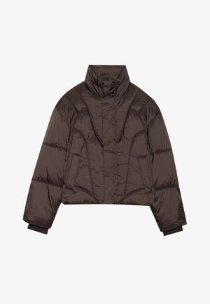 Tumši brūns īss pūkains jakas modelis ar augstu apkakli, siltu konstrukciju un garām piedurknēm ar ribinātām aprocēm, novietots uz baltas virsmas.