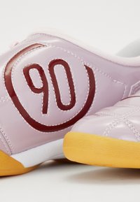 Pink patent leather shoes featuring a quilted texture, contrasting maroon '90' logo, and a yellow rubber sole.
