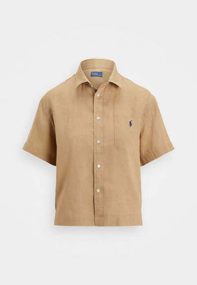 Short-sleeve linen shirt in light brown with a button-down front, chest pocket, and embroidered logo. Textured, breathable fabric.