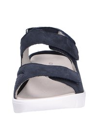 Sandales en suedine navy avec des sangles Velcro ajustables, un semelle beige rembourrée et une semelle en caoutchouc blanche. Design ouvert à l'avant avec des accents découpés.