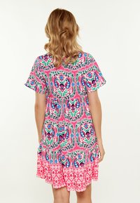 Abito rosa a maniche corte con stampa floreale e paisley colorata, orlo arricciato e vestibilità rilassata, realizzato in tessuto leggero e testurizzato.