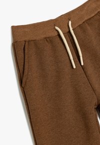 Bruine sweatpants met een geribbelde tailleband, trekkoorden en zijzakken, met een zachte, gestructureerde stofafwerking.