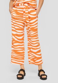 Oranje en wit gestreepte wijde broek, met een strikceintuur, zakken en een lichtgewicht stof met een soepele textuur.