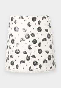 Fehér anyagból készült szoknya fekete virágmintával és kiemelkedő, texturált részletekkel. Az alsó szegély texturált szegéllyel rendelkezik. Rövid, A-vonalú fazon.