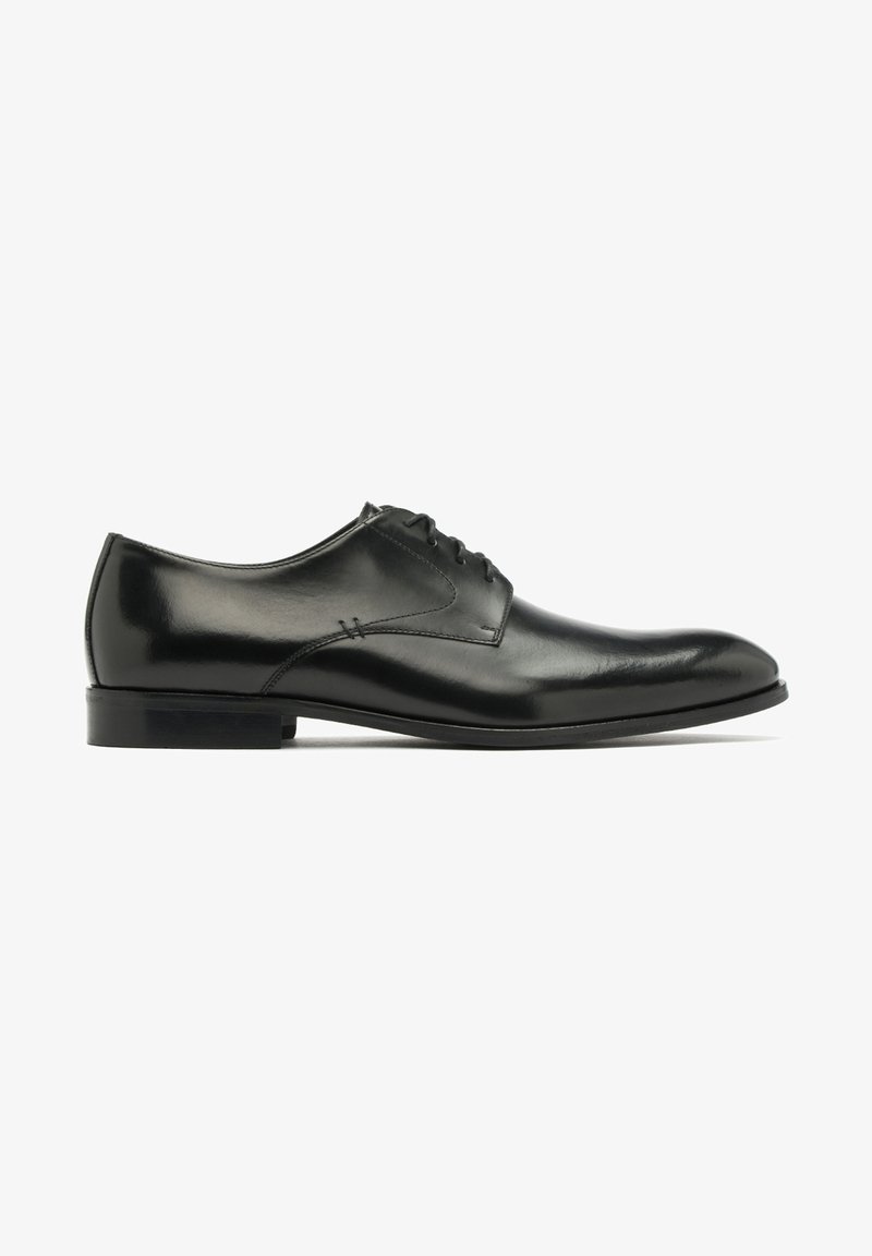 Chaussure habillée en cuir noir avec une finition lisse, un bout arrondi et six œillets pour les lacets. Dispose d'un petit talon et de détails de couture discrets.