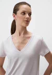 Licht lavendel V-hals t-shirt van zacht katoen, met korte mouwen en een gladde textuur, met een ontspannen pasvorm en minimale stikdetails.