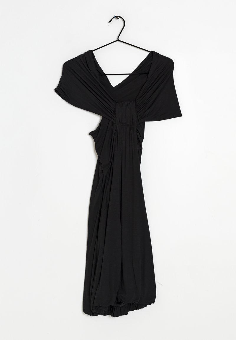 Robe noire en tissu doux, avec un décolleté en V, un corsage froncé et un design drapé, avec un ourlet froncé au bas. Accrochée à un crochet.