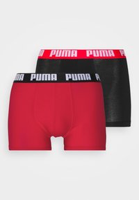 Zwei Paare Boxershorts: eines rot mit einem schwarzen Bund, das andere schwarz mit einem roten Bund, jeweils mit dem auffälligen „PUMA“-Logo.
