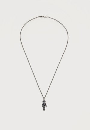 Delicate silver chain necklace with small robot-shaped pendant made of black and silver geometric stones.