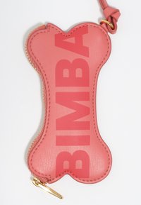 Różowy portmonetka z eko skóry w kształcie kości z tłoczonym napisem "BIMBA", złotym zamkiem błyskawicznym i pętlą do zawieszenia. Gładka faktura.