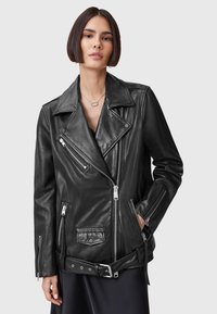 Zwart leren motorjacket met overgrote revers, asymmetrische ritssluitingen, meerdere zakken en een riem in de taille. Gladde textuur en getailleerd ontwerp.