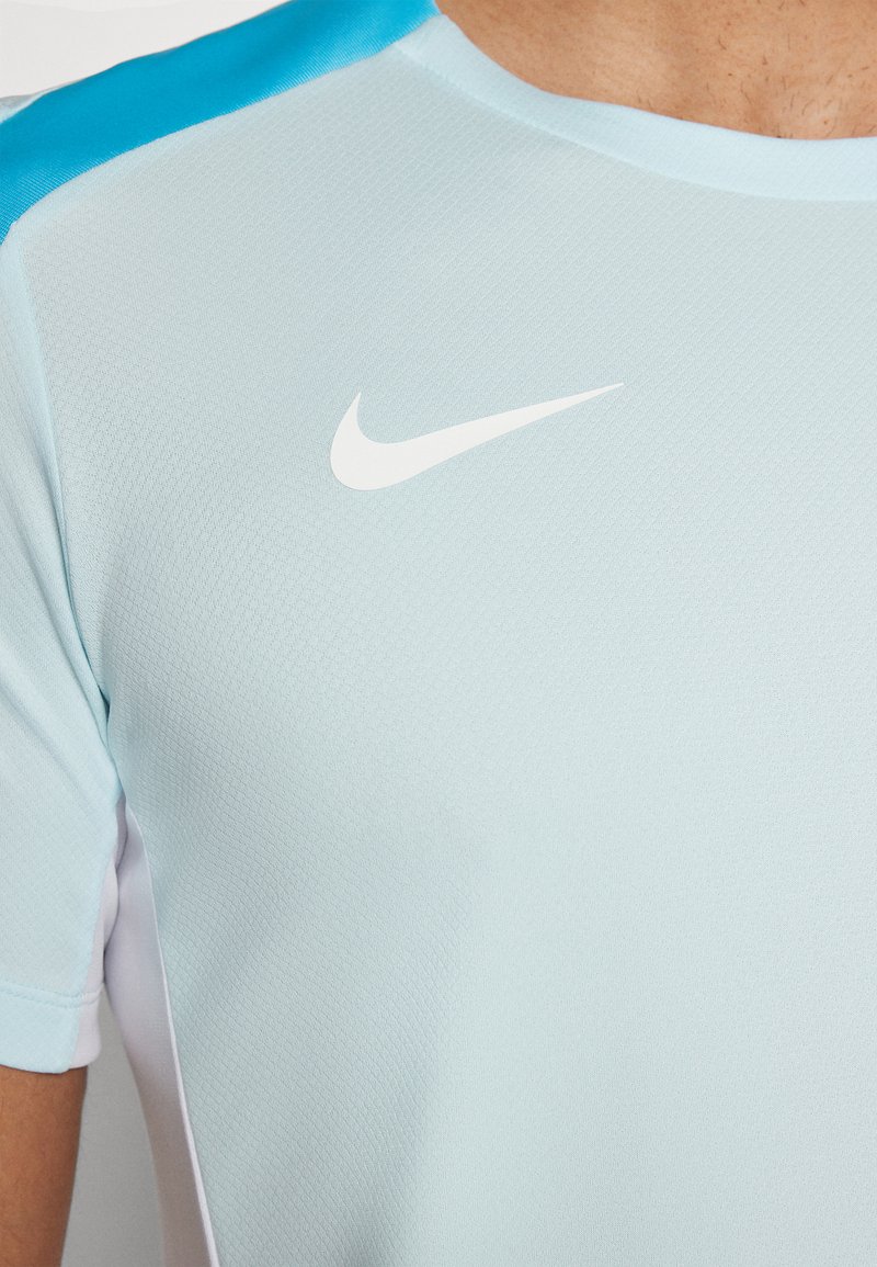 Helles blaues Nike Sport-T-Shirt mit strukturiertem Stoff, weißem Logo auf der Brust und kontrastierenden türkisen Akzenten an den Schultern.