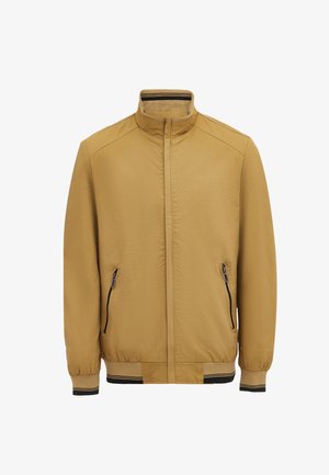 Hellbraune Zip-Jacke mit Stehkragen, zwei Seitentaschen, elastischen Bündchen und einem gerippten Saum mit schwarzen Akzenten. Glatte Textur.