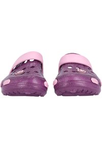 Lila Clogs mit einer glänzenden Oberfläche und pinkem Riemen. Mit Belüftungsöffnungen und einer strukturierten Sohle für besseren Halt. Funkelnde Akzente überall.