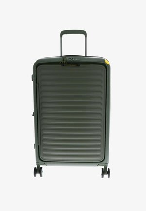 Valise rigide verte avec texture striée, poignée télescopique et quatre roues. Équipée d'un cadenas à combinaison et d'une petite accentuation jaune.