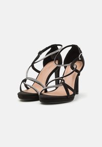 Musthave mustril sueda kõrged kontsad ristuvad rihmad ja rhinestone detailid; sisaldavad platvormi talda ja pehmendatud sisetald.