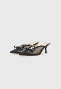 Black mesh mules with pointed toes, featuring a decorative bow on the upper, and a slim stiletto heel. Smooth inner lining, elegant design.