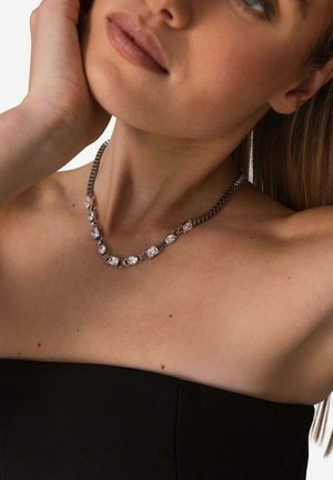 Kettenhalskette mit klaren, facettierten Steinen, die in silberfarbenen Metallgliedern gefasst sind, mit flachem Design und polierter Oberflächenveredelung.