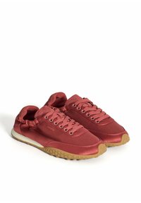 Zapatillas de satén rojo con una textura suave, que cuentan con un collar acolchado, ojales de metal y suelas de goma con un patrón de puntos.
