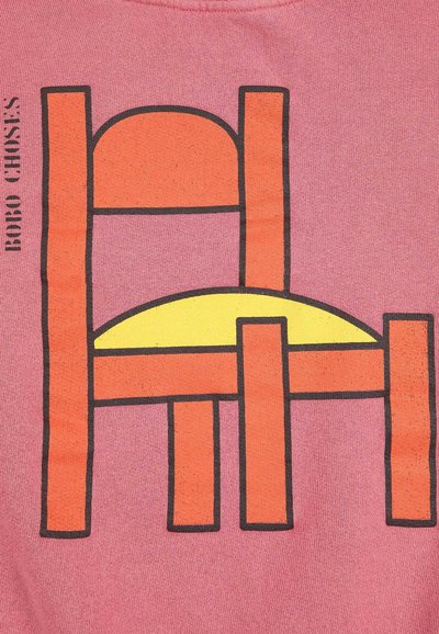 Grafikdesign auf einem pinken Stoff, der einen stilisierten Stuhl in Orange und Gelb mit schwarzen Umrissen zeigt, wobei geometrische Formen und kontrastierende Farben hervorgehoben werden.