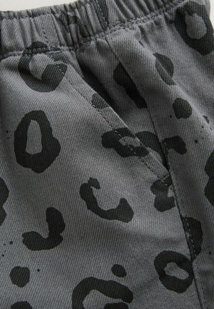 Shorts en tissu gris avec un motif imprimé léopard noir, dotés d'une taille élastique et d'une finition texturée.
