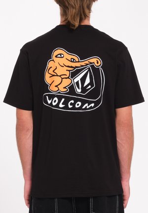 Camiseta negra de mangas cortas con un personaje de dibujos animados naranja en la parte trasera, con el texto "VOLCOM" y un diseño de forma geométrica.