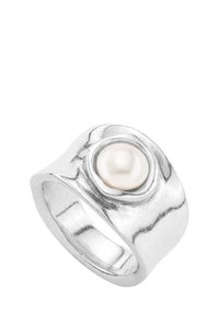 Anillo de plata con un diseño texturizado y ondulado que presenta una prominente perla blanca redonda en el centro. Superficie interior suave para mayor comodidad.