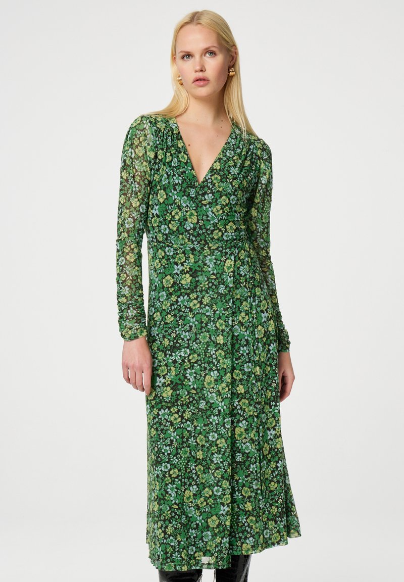 Grünes florales Wickelkleid mit langen, durchsichtigen Ärmeln, tiefem V-Ausschnitt und einem fließenden, knöchellangen Rock, der mit kleinen Mustern verziert ist.