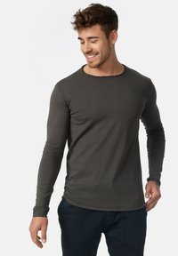 Camiseta de manga larga en color gris oscuro, fabricada con una tela suave, que presenta un cuello redondo y mangas ajustadas, con una sutil textura y sin patrones visibles.