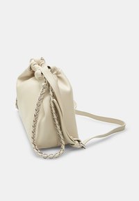 Crèmekleurige leren handtas met een geplooide bovenkant, zilveren ketting-schouderriem en een gladde textuur. Ontworpen in een compacte, rechthoekige vorm.