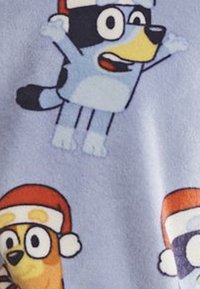 Chiens de dessin animé portant des chapeaux de Père Noël sur un fond bleu clair, exprimant l'excitation et la joie des fêtes.