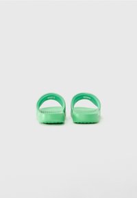 Pair of green slide sandals with textured footbeds shown from the front on a white background.