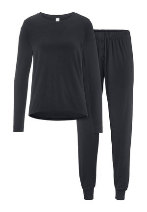 Schwarzes Langarmtop mit Rundhalsausschnitt, kombiniert mit schwarzen Hosen mit elastischem Bund, drei vorderen Knöpfen und Bündchen an den Knöcheln.