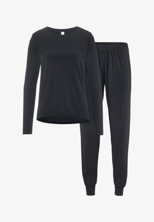 Schwarzes Langarmtop mit Rundhalsausschnitt, kombiniert mit schwarzen Hosen mit elastischem Bund, drei vorderen Knöpfen und Bündchen an den Knöcheln.