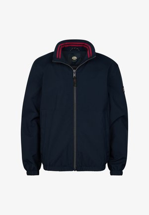 Chaqueta azul marino con cuello a rayas rojas, camiseta verde, vaqueros azules y zapatillas blancas. El material parece suave, con un ajuste informal.