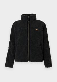 Schwarze Fleecejacke mit hohem Kragen, Reißverschluss und strukturiertem Stoff. Verfügt über zwei seitliche Taschen und ein kleines Logo-Highlight auf der Brust.