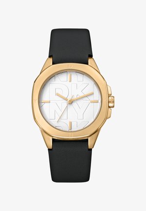 Goudkleurig horloge met een ronde wijzerplaat, witte textuur achtergrond met een gegraveerd 'DKNY' patroon, en een zwarte leren band.