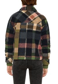 Chaqueta de forro polar con un patrón de cuadros multicolores en verde oscuro, negro y rosa, con un collar y puños de canalé verde.
