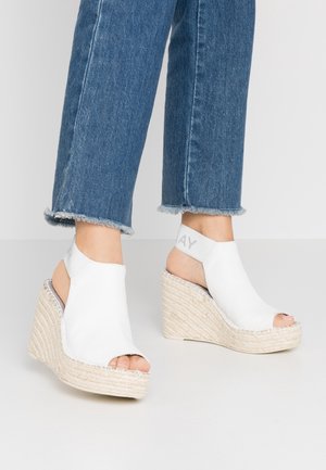 White open-toe wedge sandals with a textured synthetic upper and woven jute base. Elastic ankle strap features "PLAY" in gray.