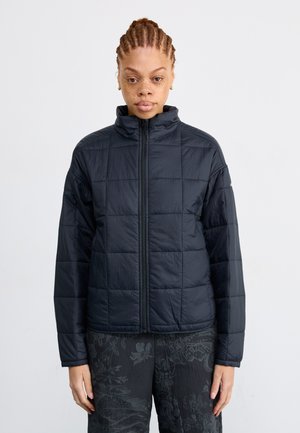 Black padded jacket with a high collar, featuring a quilted design, full front zipper, and slightly loose fit. Suitable for layering.