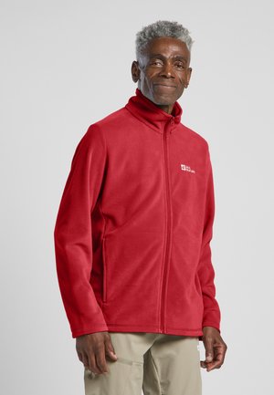 Rote Fleecejacke mit hohem Kragen und Reißverschluss vorne, ausgestattet mit seitlichen Taschen und gesticktem Logo auf der Brust. Glatte Textur, leichtes Design.