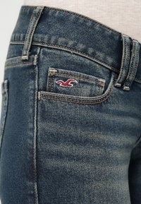 Τζιν παντελόνι από denim σε σκούρο μπλε χρώμα με σταδιακή ξεθώριαση, μια μικρή τσέπη και κόκκινο κεντημένο λογότυπο. Σχεδιασμός με πέντε τσέπες.