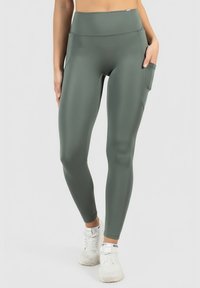 Legginsy o wysokim stanie, odprowadzające wilgoć, w stonowanej zieleni, z boczną kieszenią, gładką teksturą i dopasowanym krojem, idealne do aktywności.