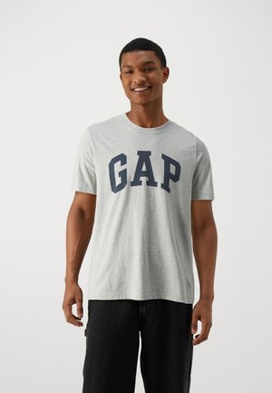 Grey cotton t-shirt featuring a dark blue "GAP" logo across the chest; round neckline, short sleeves, and relaxed fit.
