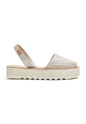Espadrilles metálicas beige con diseño de tira trasera, featuring una suela envuelta en yute texturizado y una parte superior de tela suave.
