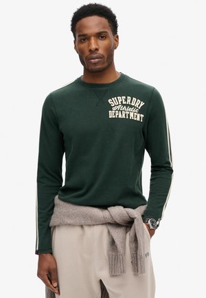 Donkergroene long-sleeve shirt met crèmekleurige tekst "SUPERDRY Athletic Department". Heeft witte zijstrepen, een zachte textuur en een ronde hals.